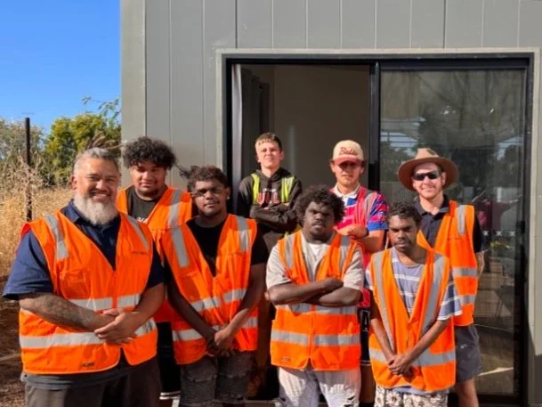 RedDoor young people in hi-vis in front of a cabin they built in North West Queensland